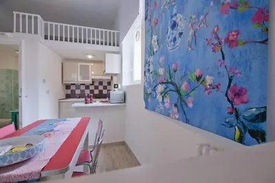 a kitchen with a table and a painting on the wall at Colosseum relax family apartament in Rome