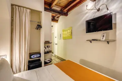 a bedroom with a bed and a television on the wall at Casa Argileto in Rome