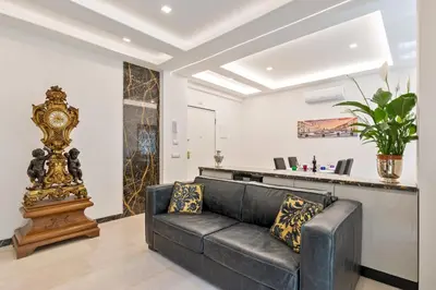 a living room with a black couch and a clock at First Class Rome Apartments in Rome