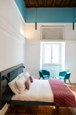 a bedroom with a large bed and two chairs at Hadrianus Temple Suites - The Venue Collection in Rome