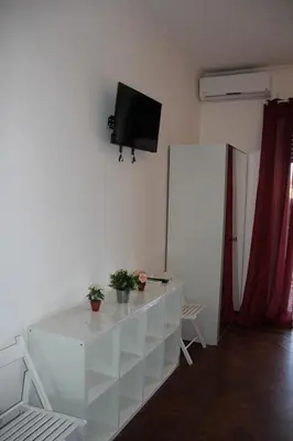 a living room with a white cabinet and a tv on the wall at Domus Vatican Holiday's in Rome