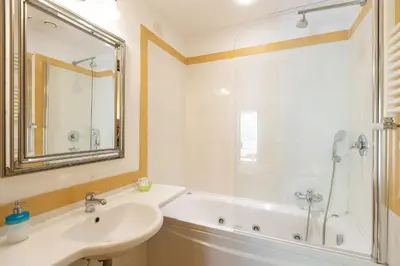 a bathroom with a white tub and a sink and a mirror at InternoUno Deluxe in Rome