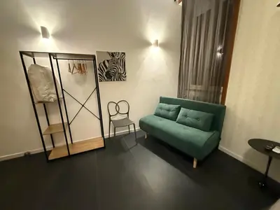a living room with a green couch and a chair at Claudio My House in Rome