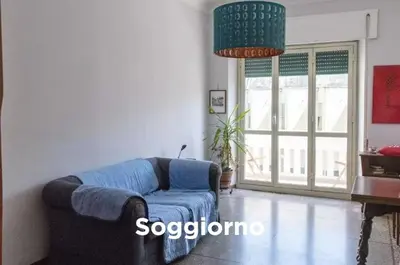 a living room with a blue couch and a large window at Easylife in Rome