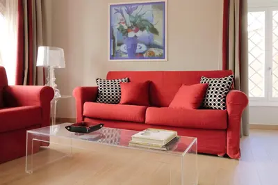 a living room with a red couch and a glass table at Piazzetta Margutta - My Extra Home in Rome