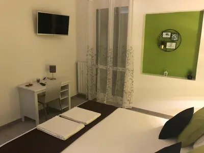 a living room with a desk and a green wall at The Royals in Rome