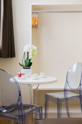 two chairs and a table with a vase of flowers at Demetra Eco Guest House in Rome