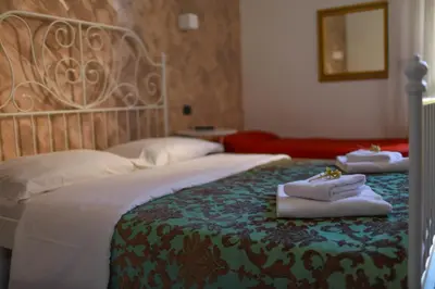 a bedroom with a bed with two towels on it at Hotel Pisa in Rome