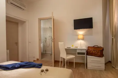 a hotel room with a desk and a bed and a computer at Domus Veneto Rome in Rome