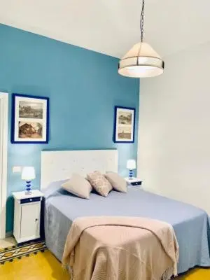 a blue bedroom with a bed with a blue wall at Mama Roma Domus in Rome