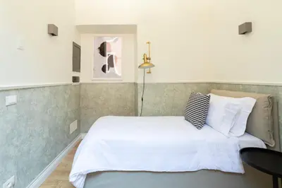 a bedroom with a white bed and a table at Louly Spanish Steps in Rome