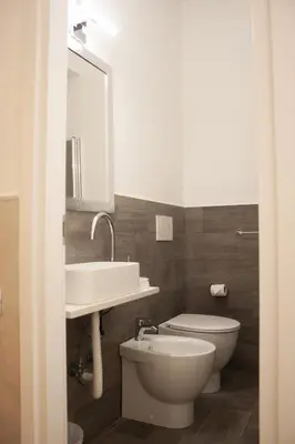 a bathroom with a sink and a toilet and a mirror at Rubino Guest House in Rome