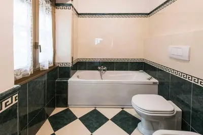 a bathroom with a white tub and a toilet at Eucalyptus Resort - Roma San Paolo - in Rome