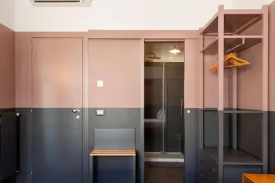 a room with a closet with a table and a glass door at MODO Rooms & Suite Rome in Rome