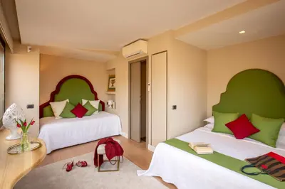 a bedroom with two beds with green and red pillows at Nido del Gambero - Your Suite with View in Rome