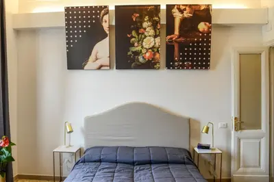 a bedroom with a bed with three pictures on the wall at San Pietro Suite Rome in Rome