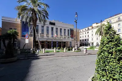 a city street with a palm tree in front of a building at Opera 58 - Teatro dell'Opera Suites in Rome