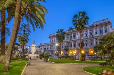 a building with palm trees in front of it at The Shell Rome Suite in Rome
