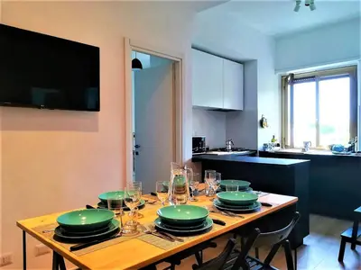 a wooden table with green plates and glasses on it at VATICAN APARTMENT MELORIA in Rome