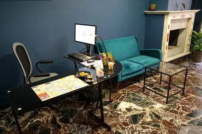 a living room with a couch and a desk with a computer at Regolo Rooms Vaticano in Rome