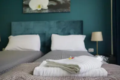 a bedroom with two beds and a blue wall at Regolo Rooms Vaticano in Rome