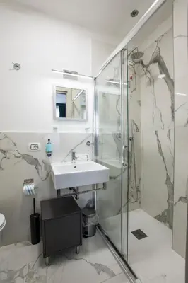 a bathroom with a sink and a shower at Regolo Rooms Vaticano in Rome