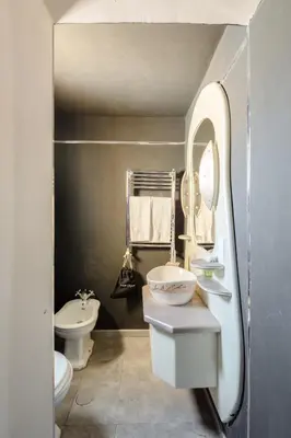 a bathroom with a sink and a toilet and a mirror at Rooftop Colosseo - Roma d'Amore in Rome