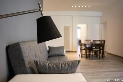 a living room with a couch and a table with chairs at Nido di Pina in Rome