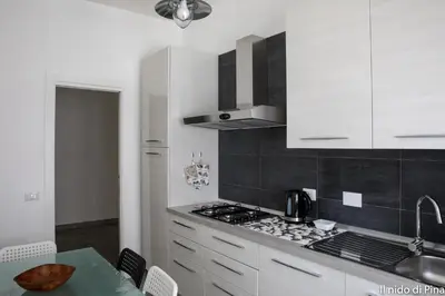 a kitchen with white cabinets and a stove top oven at Nido di Pina in Rome