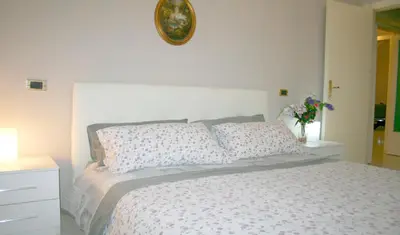 a white bed with pillows and a clock on the wall at Montebello - Julia Apartment in Rome