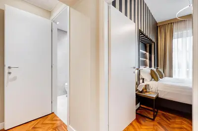 a bedroom with a large white door leading to a bed at Frattina High-end apt in Rome