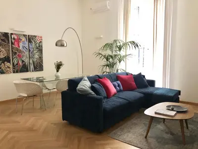 a living room with a blue couch and a table at Opera Luxury Rosmini in Rome