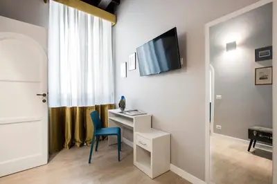 a room with a desk and a tv on a wall at La Finestra su Fontana di Trevi - Charming View in Rome