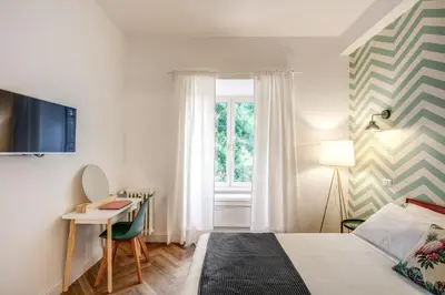 a bedroom with a bed and a desk and a window at Trastevere 2.0 in Rome
