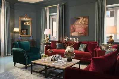a living room with red couches and green chairs at Rocco Forte House Piazza Di Spagna, Rome in Rome