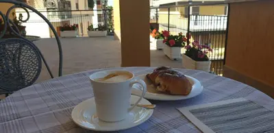 a cup of coffee and a pastry on a table at In Terrazza Da Giusy in Rome