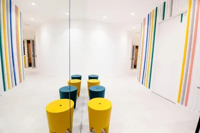a hallway with yellow and blue stools at O.Effe. Suites / Vatican in Rome
