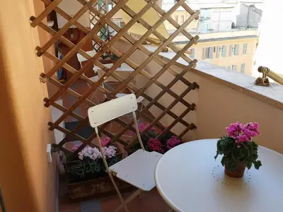 a white table and chairs on a balcony with flowers at Affreschi al Vaticano in Rome