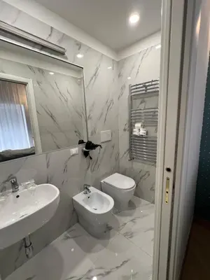 a white bathroom with a sink and a toilet at Affreschi al Vaticano in Rome