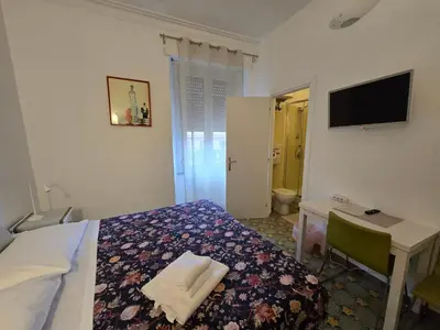 a bedroom with a bed and a desk and a television at Chez Liviana in Rome