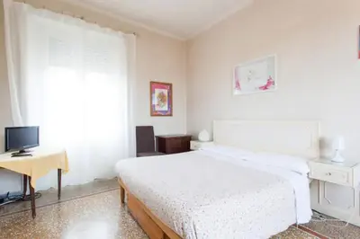 a bedroom with a bed and a desk and a television at Chez Liviana in Rome
