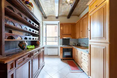 a kitchen with wooden cabinets and a large window at Kyterion Apartment in Rome