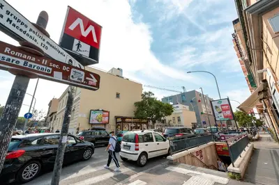 a man crossing a street in a busy city with cars at Kyterion Apartment in Rome