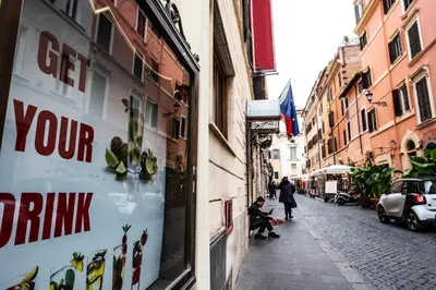 a street with a shop window in a city at La Vite 94 in Rome