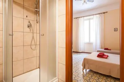 a bathroom with a shower and a bed in a room at Furio Camillo in Rome