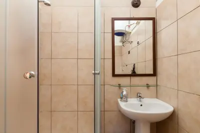 a bathroom with a shower with a sink and a mirror at Furio Camillo in Rome