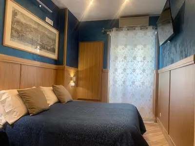 a bedroom with a bed with blue walls at B&B Acasadibarbara in Rome