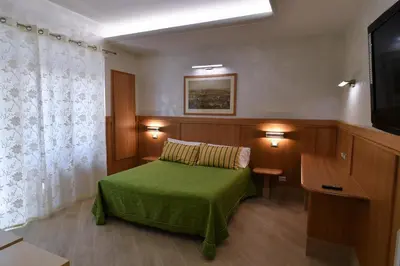 a bedroom with a green bed and a television at B&B Acasadibarbara in Rome