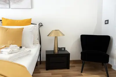 a bedroom with a bed and a chair and a lamp at Barcaccia Luxury Suites in Rome