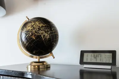 a globe on a table next to an alarm clock at Barcaccia Luxury Suites in Rome